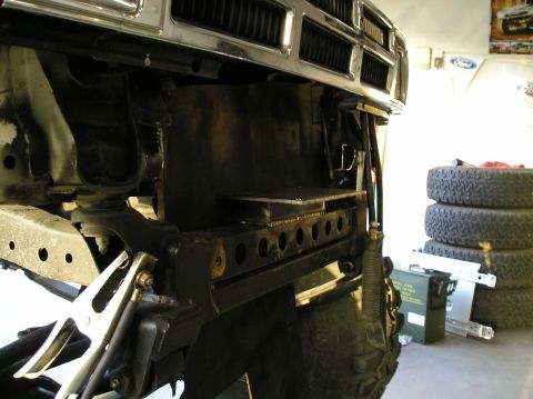 1986 Toyota Hilux - Custom front bumper bracketry is being installed on a vehicle. Tires and an ammo can are visible in the background.