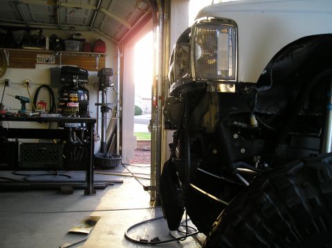 1986 Toyota Hilux - Truck front end in a garage, showing headlight and tire detail.