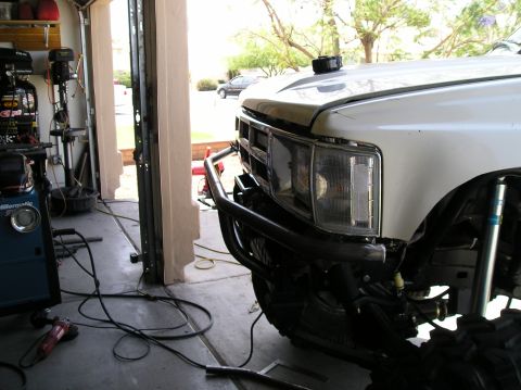 1986 Toyota Hilux - Custom brush guard installed on the front of a white pickup truck in a garage.
