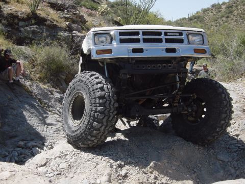 1986 Toyota Hilux - This heavily modified 1986 Toyota Hilux is shown off-roading on a rocky trail.