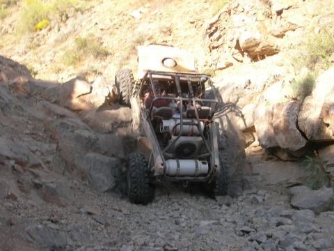 1986 Toyota Hilux - This custom buggy navigates a challenging rocky terrain, its off-road capabilities.