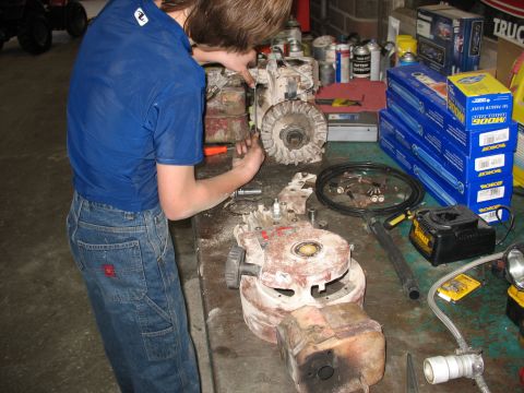 1978 Ford Bronco - Disassembled engine components and tools are laid out on a workbench for repair.