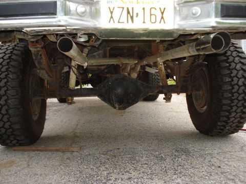 1981 Ford F-250 - The underside of a pickup truck is visible, focusing on the rear axle and dual exhaust system.