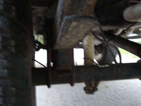 1981 Ford F-250 - Close-up view of the rear suspension components of a truck, showing leaf springs and a tire.