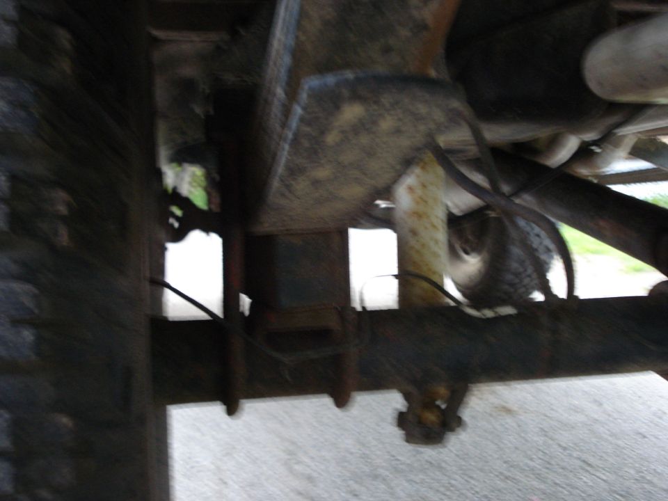 Undercarriage view of truck suspension with leaf springs and tire