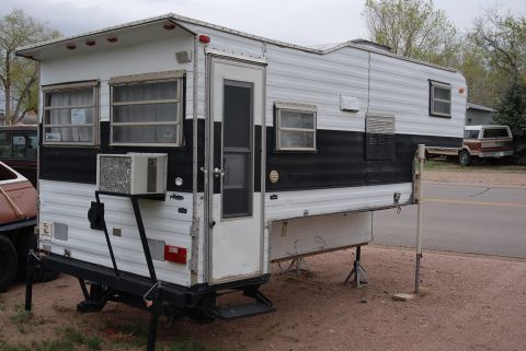 1987 Ford F-250 - This slide-in camper is set up for stationary use, supported by jacks.