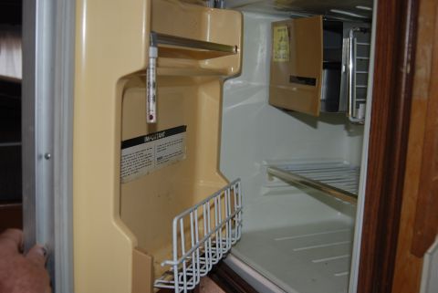 1987 Ford F-250 - The inside of a vintage refrigerator shows a thermometer and a wire basket, with shelves visible.