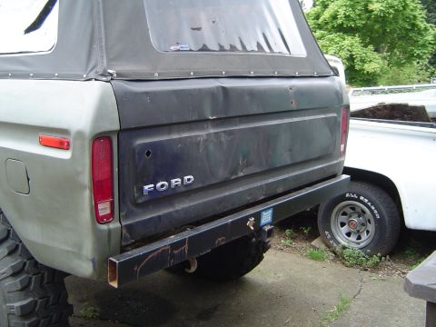 1978 Ford Bronco - This 1978 Ford Bronco features a soft top and a dented tailgate, with another vehicle visible to the right.
