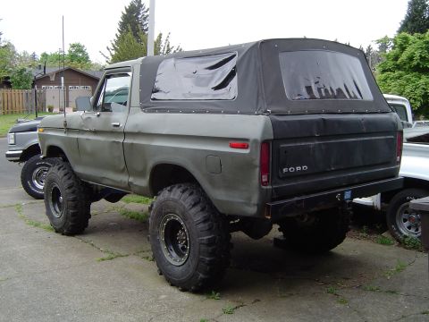 1978 Ford Bronco - Rear view of a lifted 1978 Ford Bronco a soft top and large off-road tires.