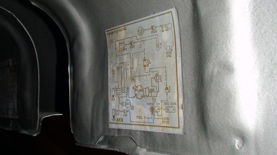 Vacuum hose routing sticker on an interior panel with AKV calibration code