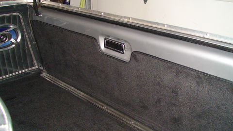 1979 Ford Bronco - The interior cargo area of a 1979 Ford Bronco features dark carpeting and a visible speaker.