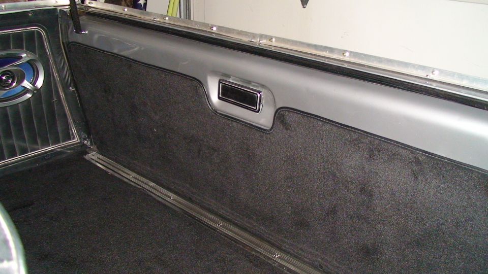 1979 Ford Bronco interior cargo area with dark carpet and speaker