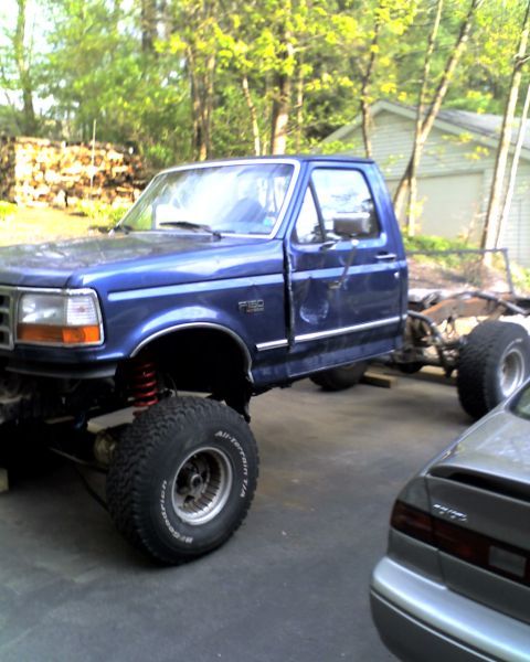 1996 Ford F-150 - This blue 1996 Ford F-150 chassis is shown with a lifted suspension and large off-road tires, suggesting a custom build or restoration proj…