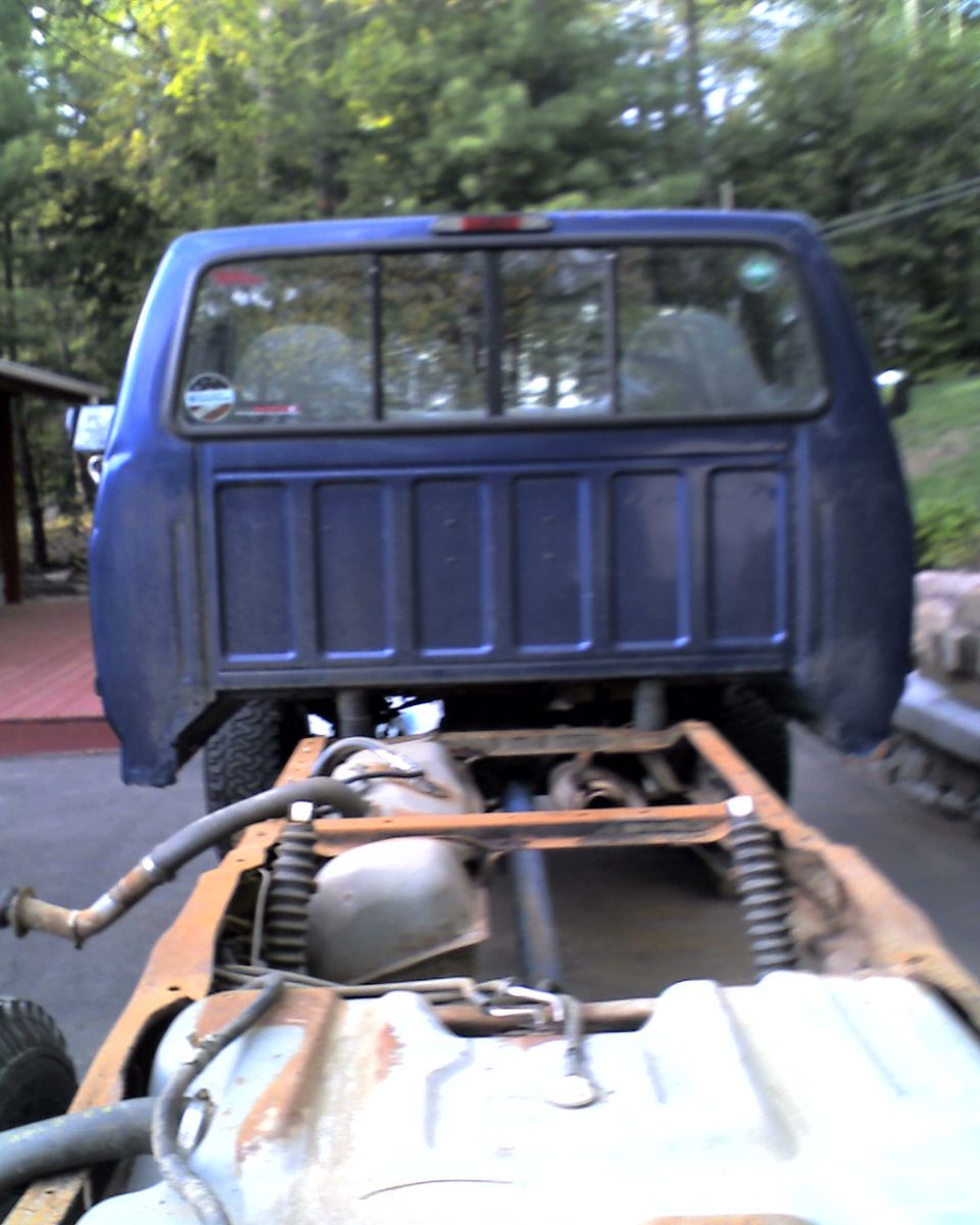 Blue truck bed and chassis, rear view. Watermark reads SUPERMOTORS.NET