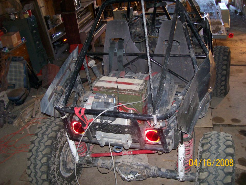 Rear view of a custom buggy with roll cage, off-road tires, and a winch