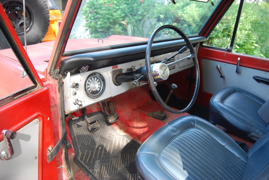 1977 Ford Bronco interior showing dashboard, steering wheel, seats, and floor pedals