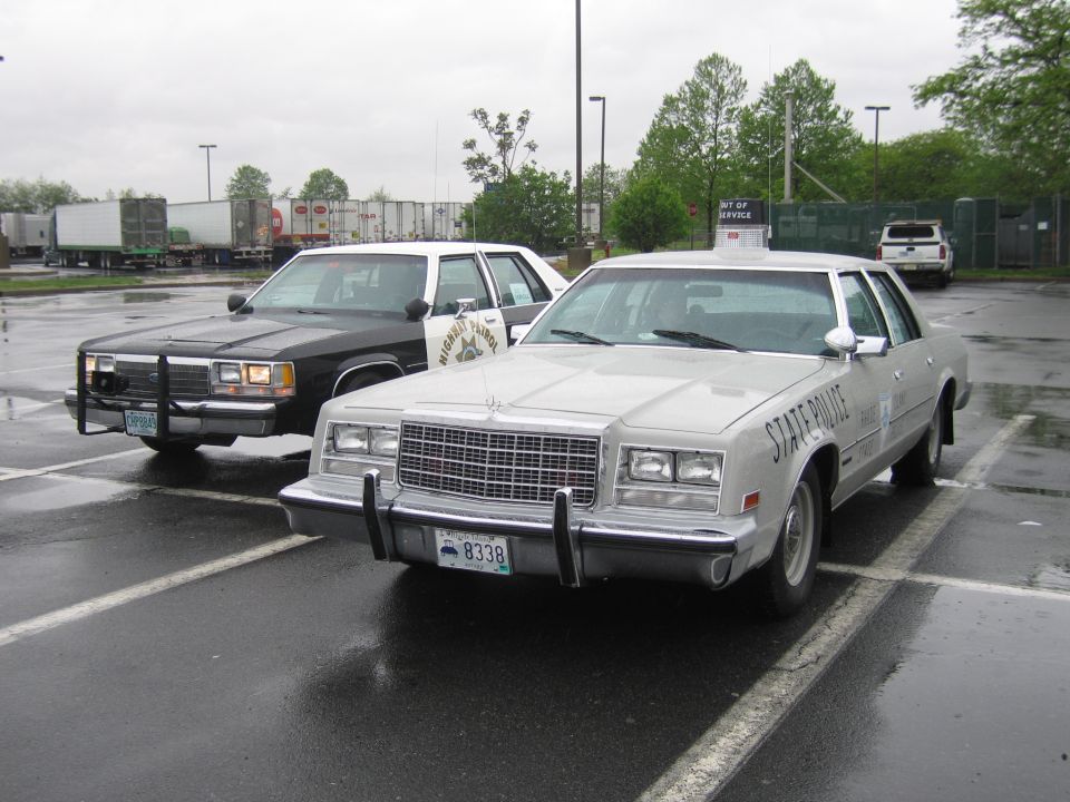 Silver State Police sedan and black car with push bar on wet lot