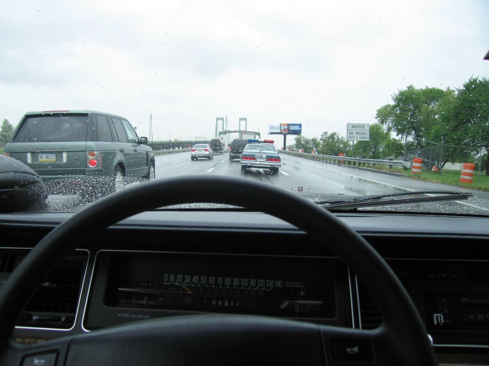 Dashboard view through windshield of police car on rainy highway