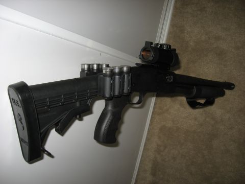 1978 Ford Bronco - A tactical shotgun is shown mounted on a wall, equipped with an optic and shell carrier.