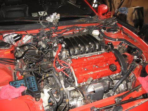 1991 Mitsubishi 3000GT - The engine bay of a 1991 Mitsubishi 3000GT shows its V6 DOHC 24V engine with red valve covers.
