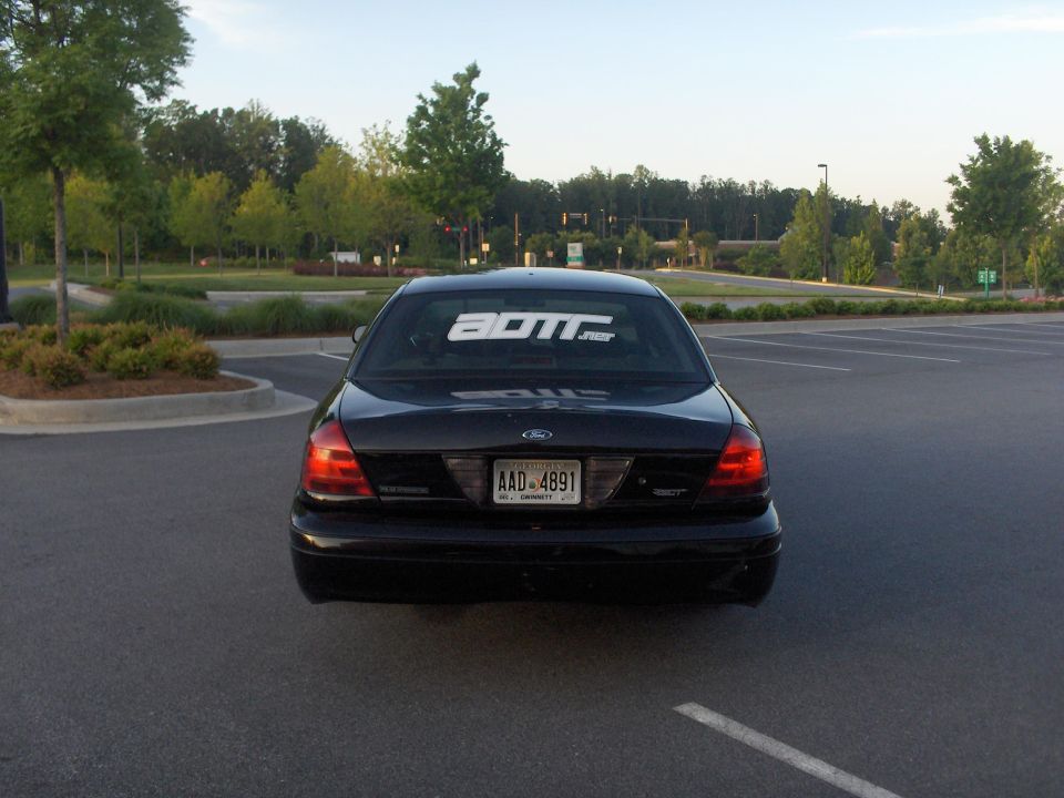 Black 2001 Ford Crown Victoria with a "BOTT.net" sticker on the rear window and license plate AAD-4891