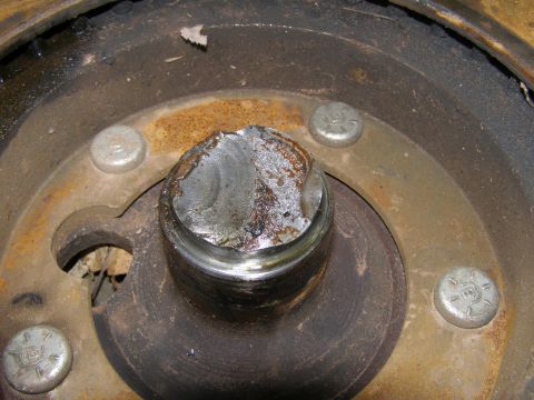 1993 Ford Bronco - A close-up view shows a damaged metal component with a broken bolt head in the center, surrounded by other bolts and rusty metal surfaces.