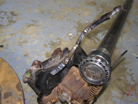 1993 Ford Bronco - A close-up view of a disassembled vehicle axle assembly with a bearing and part of a brake rotor visible. The parts appear to be rusty and…