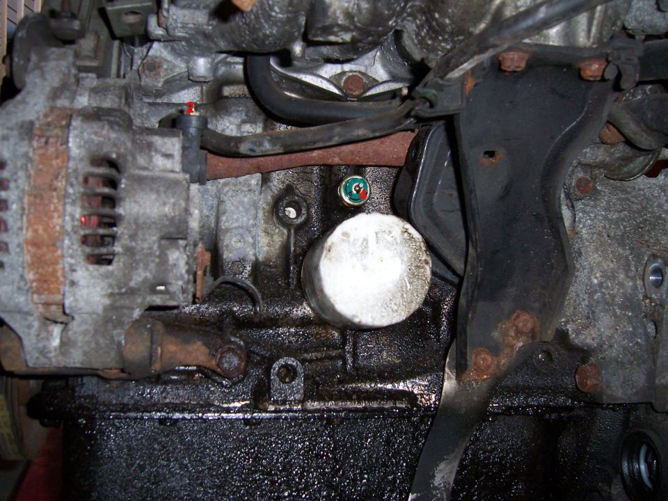 Close-up of engine block with alternator, white oil filter and annotated connector