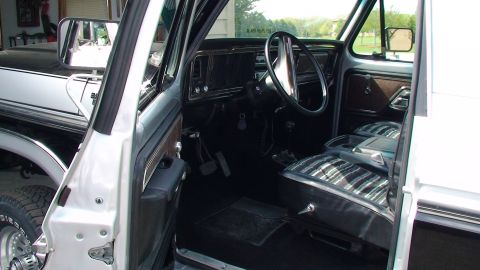 1979 Ford Bronco - The interior of a 1979 Ford Bronco reveals its classic design with striped upholstery and a functional dashboard.