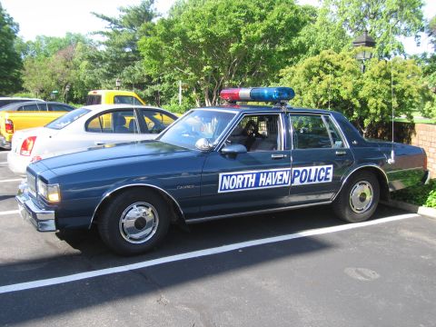 1991 Ford LTD Crown Victoria - dark blue Chevrolet Caprice sedan lettered North Haven Police with a roof lightbar, parked in a lot.