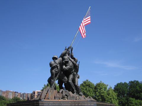 1991 Ford LTD Crown Victoria - bronze Marine Corps War Memorial depicts servicemen raising the American flag, set against a clear blue sky with trees behind.