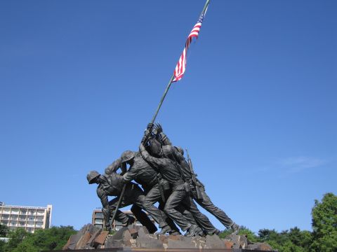 1991 Ford LTD Crown Victoria - side view of the bronze Marine Corps War Memorial statue, figures hoisting the American flag against a deep blue sky.