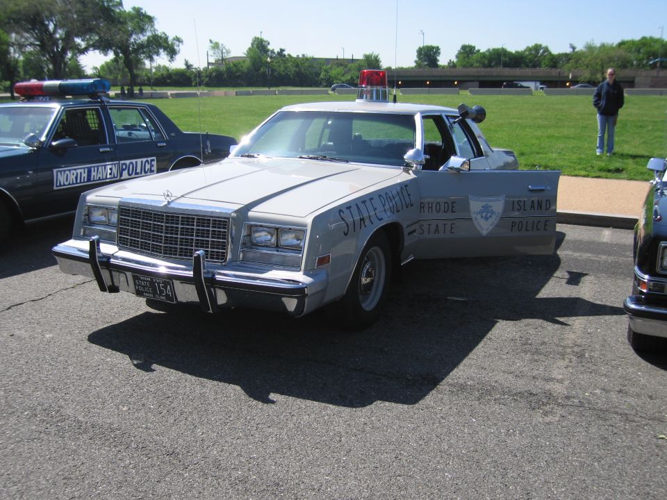 Front three-quarter view of silver Rhode Island State Police sedan