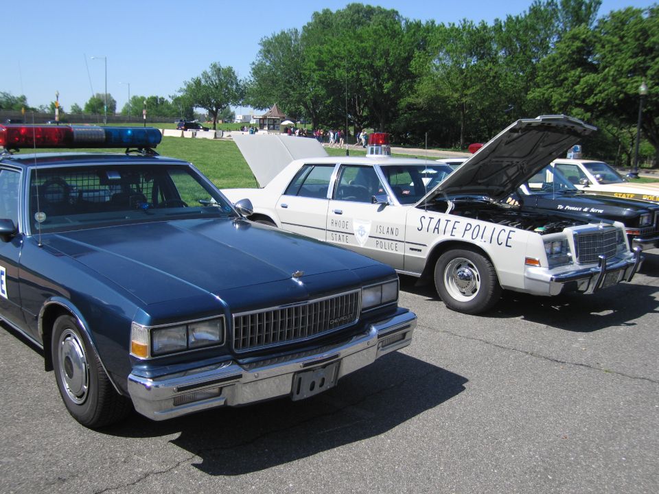 Lineup of vintage police cars including blue, white and State Police sedans