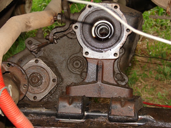 Close-up of rusty vehicle transmission and transfer case components with mounting hardware.