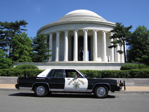 1991 Ford LTD Crown Victoria - black-and-white Highway Patrol sedan with a gold star door shield parked before the domed Jefferson Memorial.