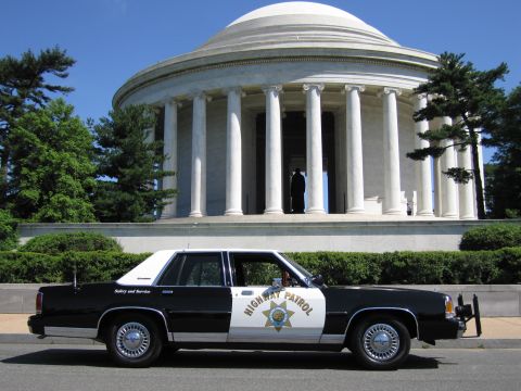 1991 Ford LTD Crown Victoria - black-and-white Highway Patrol sedan with a star shield seen in profile before the columned Jefferson Memorial.