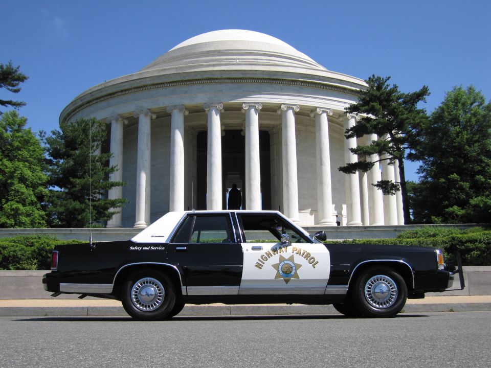 Black-and-white Highway Patrol sedan in profile at the Jefferson Memorial