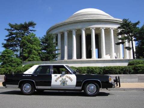 1991 Ford LTD Crown Victoria - black-and-white Highway Patrol sedan with a gold star door emblem sits before the domed Jefferson Memorial.