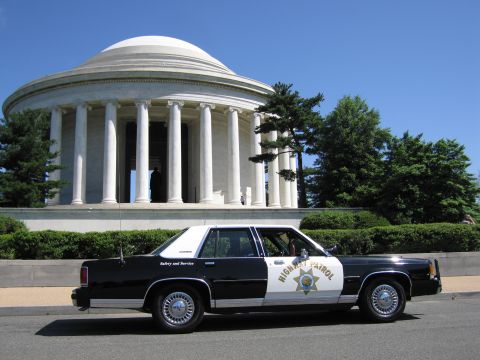 1991 Ford LTD Crown Victoria - black-and-white Highway Patrol sedan with a gold star emblem parked before the domed, columned Jefferson Memorial.