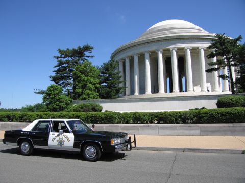 1991 Ford LTD Crown Victoria - black-and-white Highway Patrol sedan parked along a curb with the columned, domed Jefferson Memorial behind it.