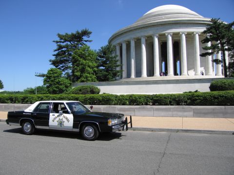 1991 Ford LTD Crown Victoria - black-and-white Highway Patrol sedan with a front push bar parked before the domed Jefferson Memorial.