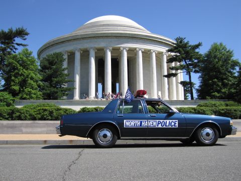 1991 Ford LTD Crown Victoria - dark blue North Haven Police sedan with a red roof light sits before the white columned, domed Jefferson Memorial.