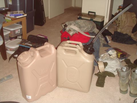1992 Ford Bronco - Two plastic jerry cans are on the floor next to scattered clothing and boots. One jerry can is light brown and labeled "WATER 20L", and the…