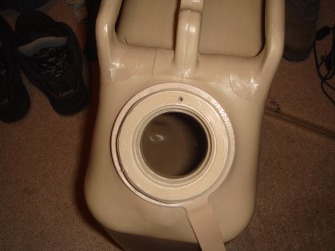 1992 Ford Bronco - Close overhead view of a tan/desert-sand plastic jerry can with its large threaded filler neck uncapped, the cap ring and coarse threads vi…