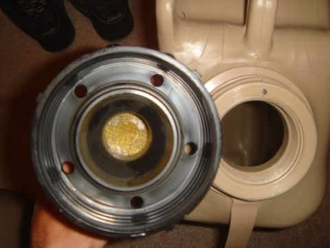 1992 Ford Bronco - A person holds a fuel cap next to an open jerry can, revealing a mesh filter inside the cap.