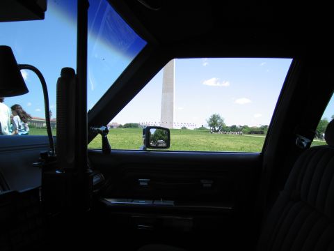 1991 Ford LTD Crown Victoria - View from inside a vehicle's cabin through the side window toward the Washington Monument on a sunny day.
