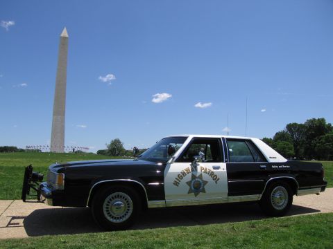 1991 Ford LTD Crown Victoria - Front-quarter view of a black-and-white Highway Patrol sedan with push bar parked on a path near the Washington Monument.