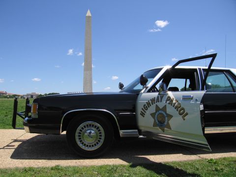 1991 Ford LTD Crown Victoria - Front-quarter close view of a black-and-white Highway Patrol sedan with push bar parked before the Washington Monument.