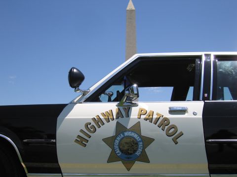 1991 Ford LTD Crown Victoria - Close view of a black-and-white police sedan door showing the "Highway Patrol" lettering and California Highway Patrol star shield.